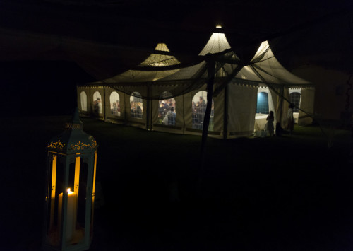 Night time view of the dinner tent lit up in the dark