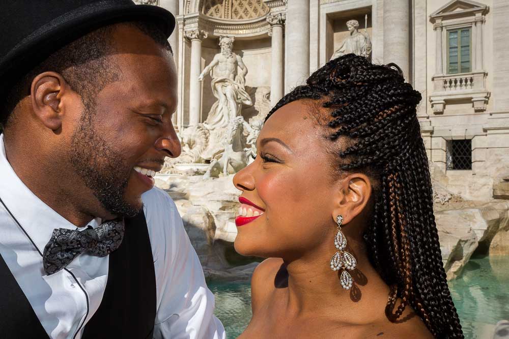 Closeup image of a couple together at the Trevi water fountain