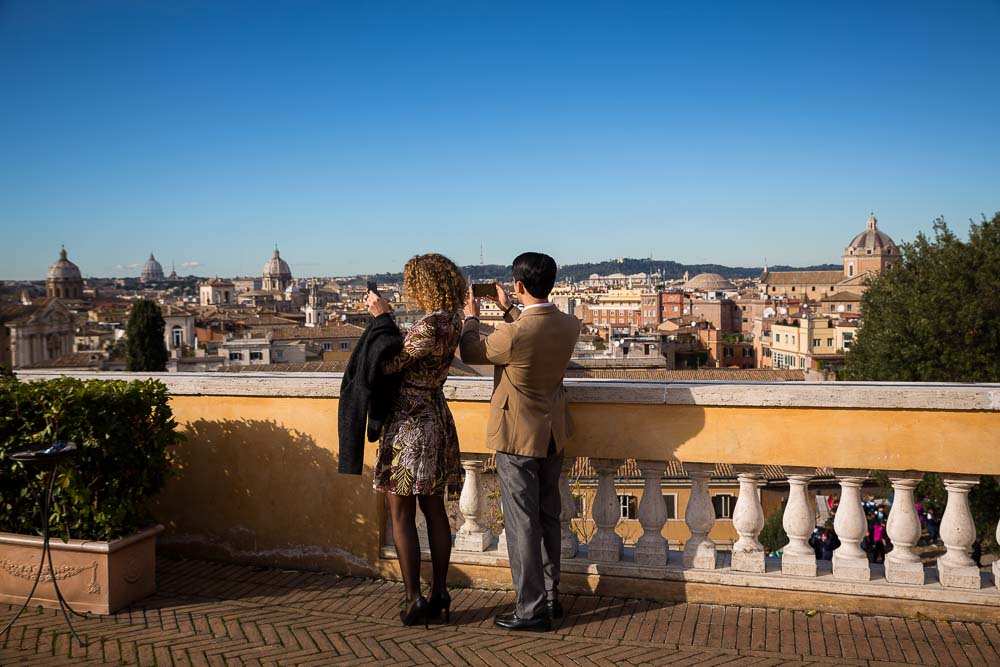 People taking pictures of the sweeping panoramic view over the city of Rome