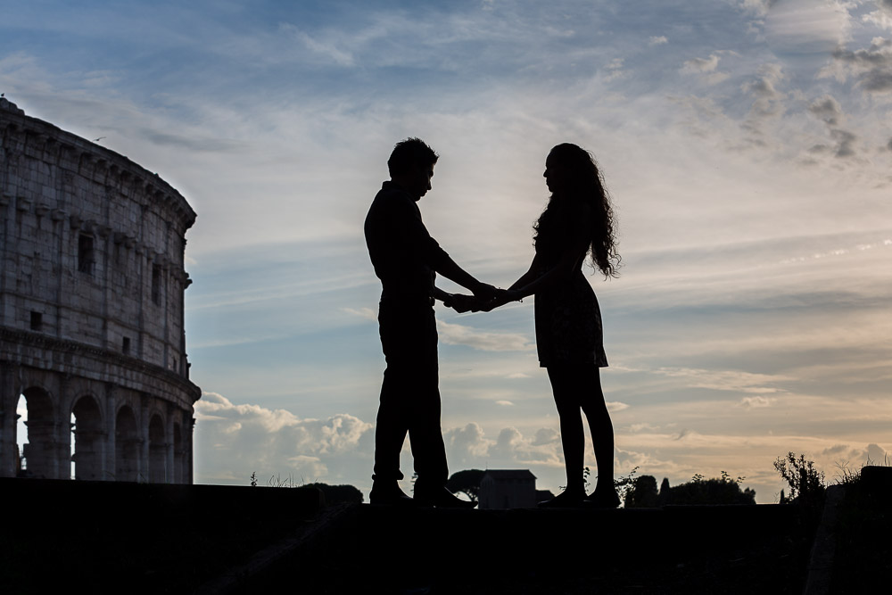 Silhouette image of a engaged couple standing before the Roman Colosseum in Rome