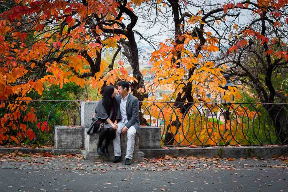 Autumn leaves. Fall engagement session. Couple under colorful tree with leaves