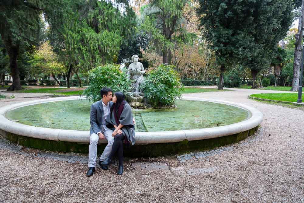 Picture of an engaged couple at a water fountain in green