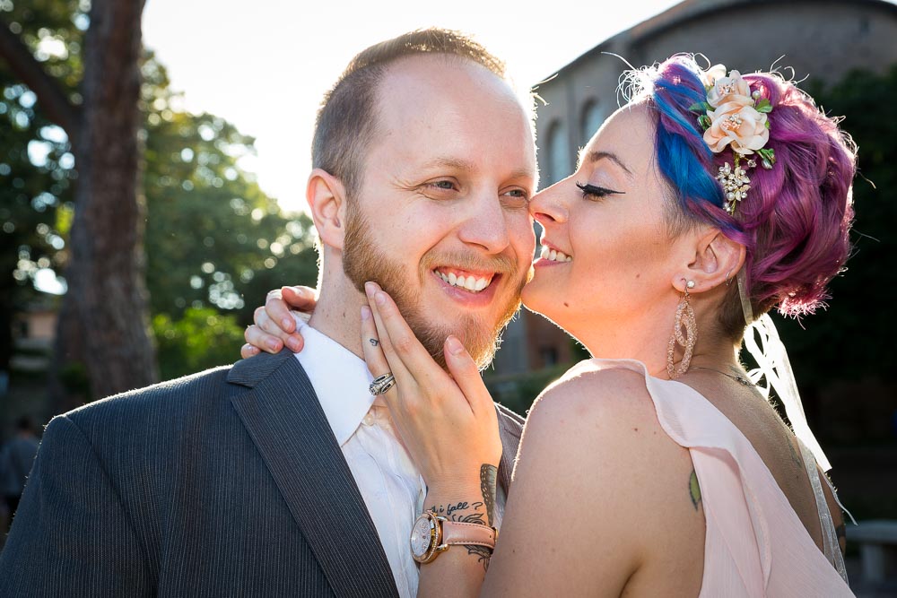 Smiling kissing pose having fun during a photo session with back light