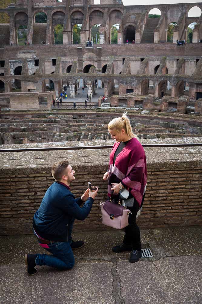 Man proposing inside the roman Colosseum in Rome Italy