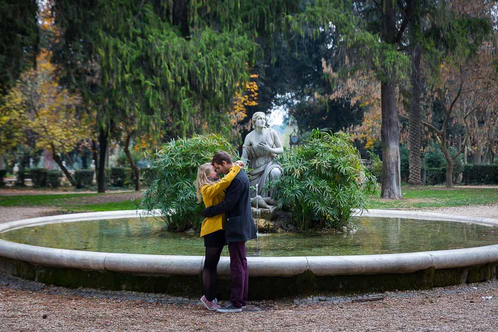 Couple photo session by a circular water fountain in parco villa Borghese