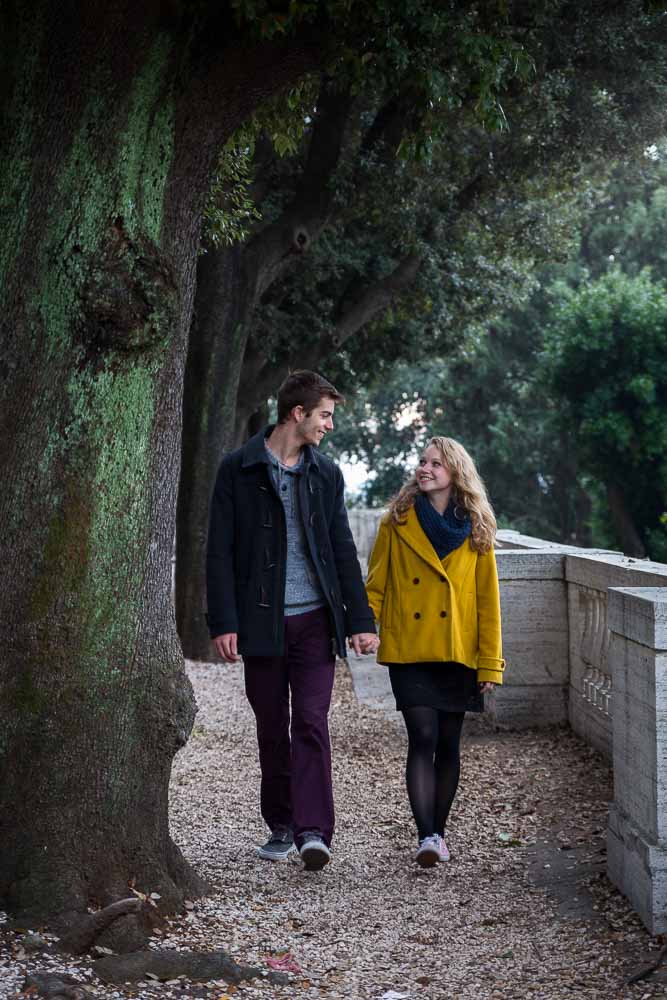 Walking together hand in hand in between park trees