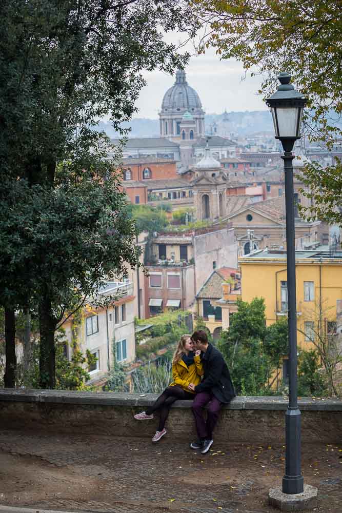 Sitting and hanging out beofre the stunning rooftop view of the city of Rome Italy during an engagement photoshoot