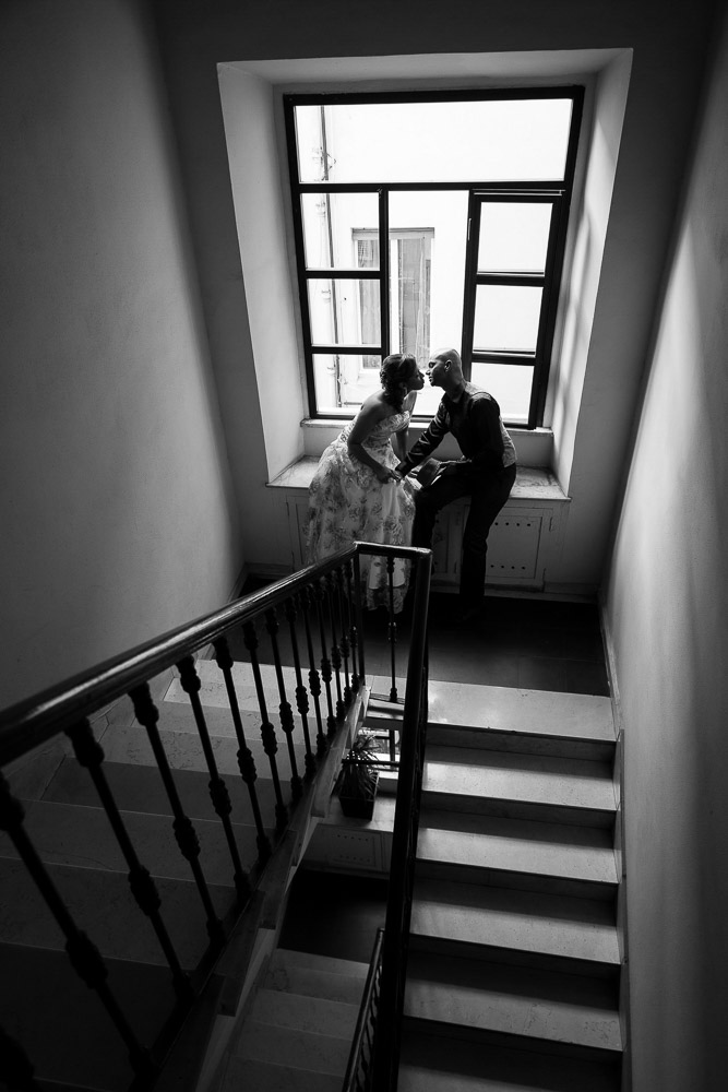 Couple romantically kissing on a staircase. Engagement style photo shoot.