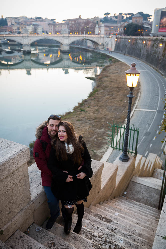 Engaged couple posing during an e-session over the Tiber river