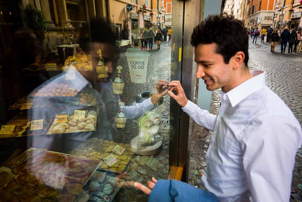 Man looking into a window food store reflection