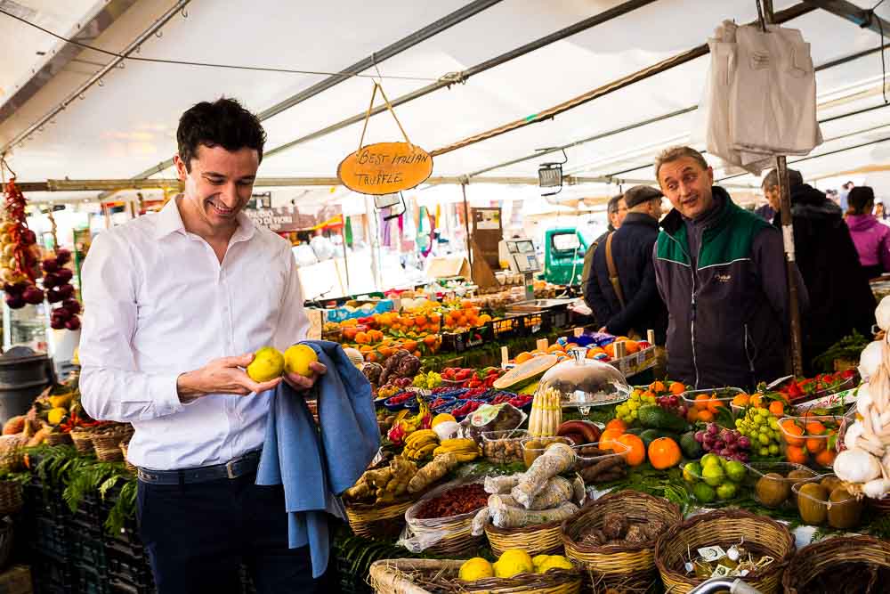 Guy picking up fruits at a vegetable and fruit market