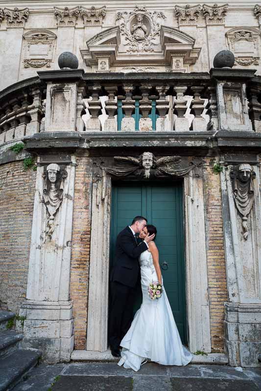 Kissing by an ancient door by a roman staircase