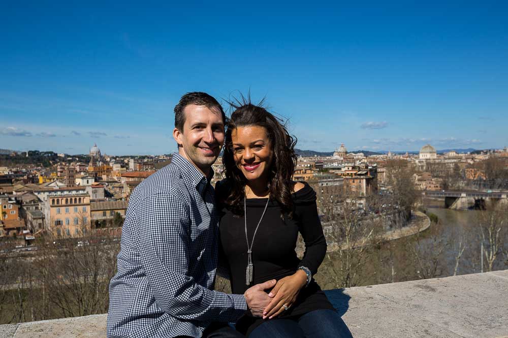 Couple sitting down over the view of the city of Rome Italy