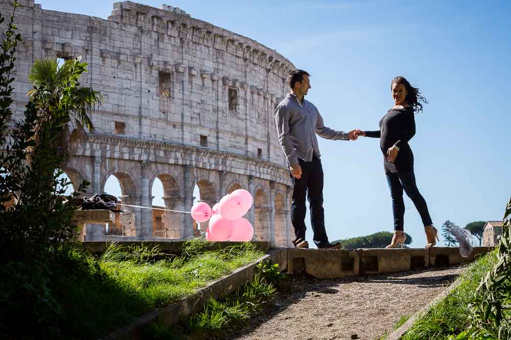 Holding hands overlooking the Colosseo. Maternity Photographer in Rome