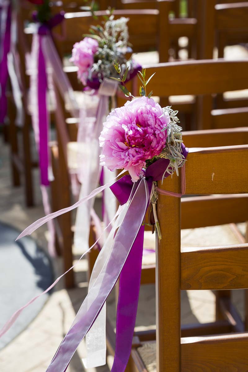 Glowers on the side of the ceremony chairs