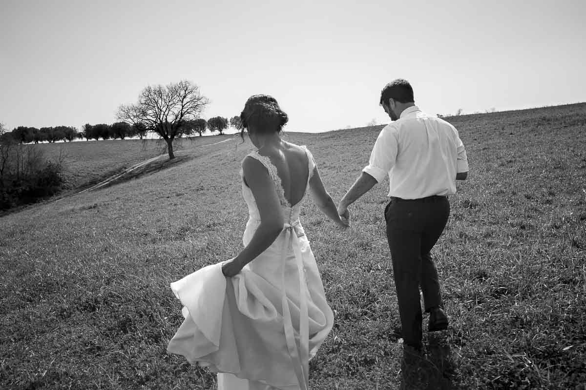 Bride and groom walking together in an Italian field