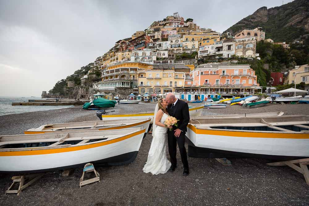 Bride and groom portrait on the beach in front of the town. Wedding photographer Positano Italy 