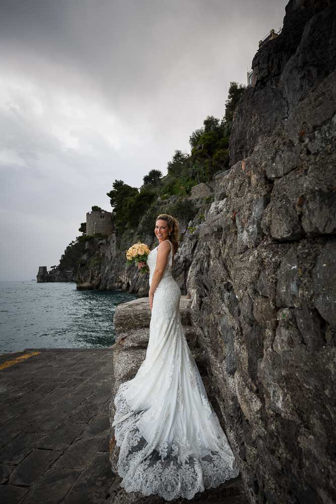 Bride portrait with wedding dress posing on the stairs. Amalfi coast. wedding photographer positano