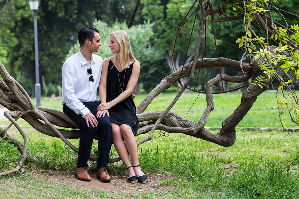 Portrait picture taken of a couple sitting down on an interesting plant seat