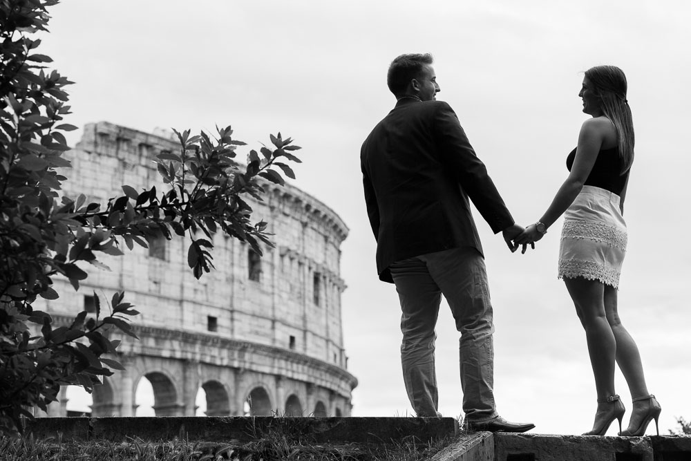 Black and white image of a couple engaged in Rome Italy by the Roman Coliseum