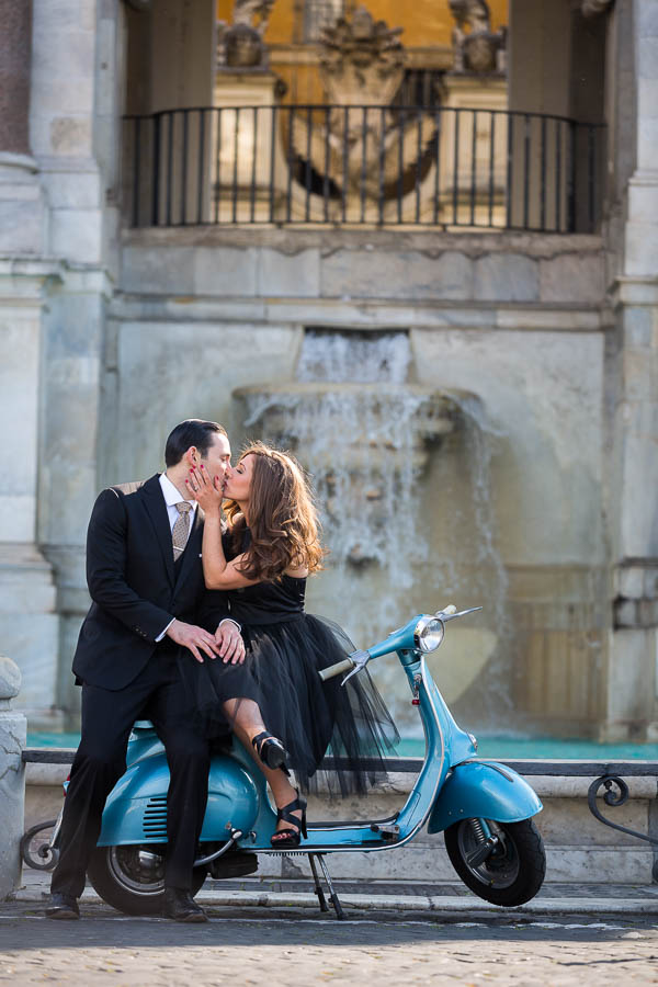 Couple kissing sitting on an Italian Piaggio Vespa during a Rome wedding honeymoon photo shoot