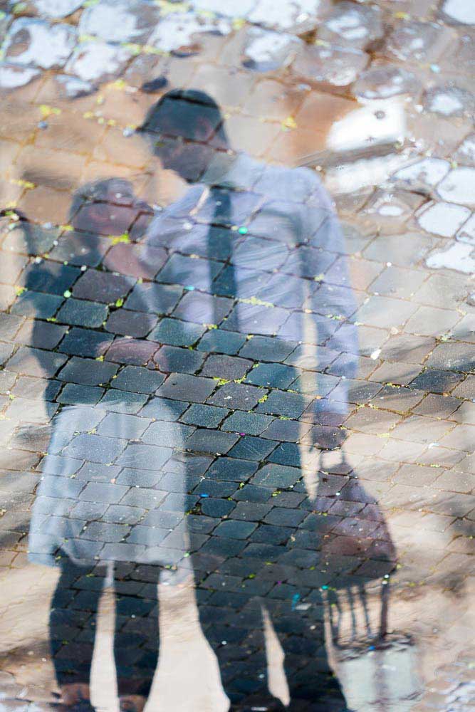 Water reflection on a puddle over cobble stone street