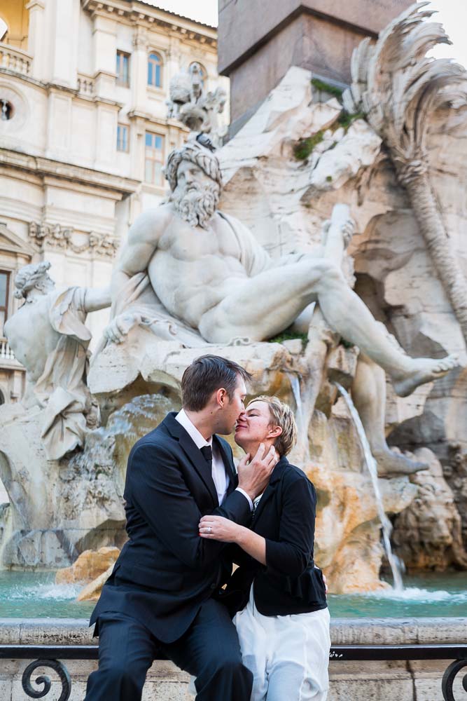 Couple kissing at Fontana dei Quattro Fiumi found in the center of Piazza Navona