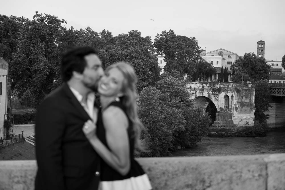 In love in Rome with an ancient distant bridge in the background