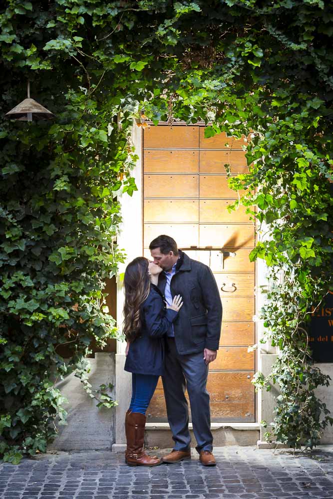 Kissing by a door with ivy leaves in the roman streets