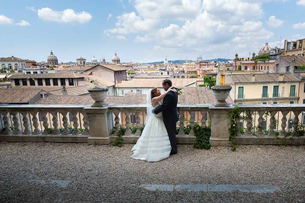 Just married in Rome. Groom and bride looking over the city of Rome from a panoramic view point