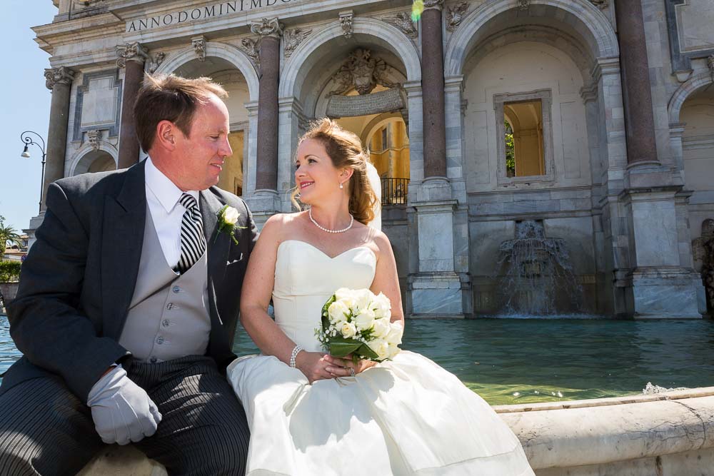 Bride & groom sitting down by the Janiculum water fountain