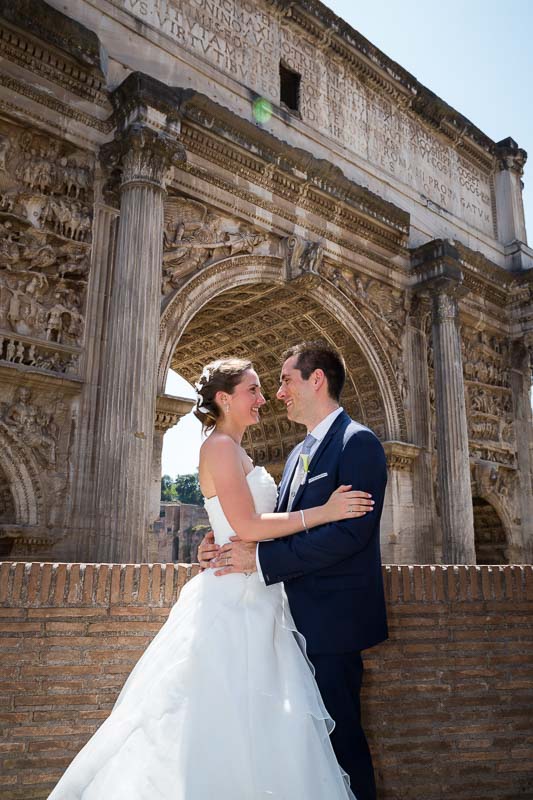 Just married couple photographed by a roman arch