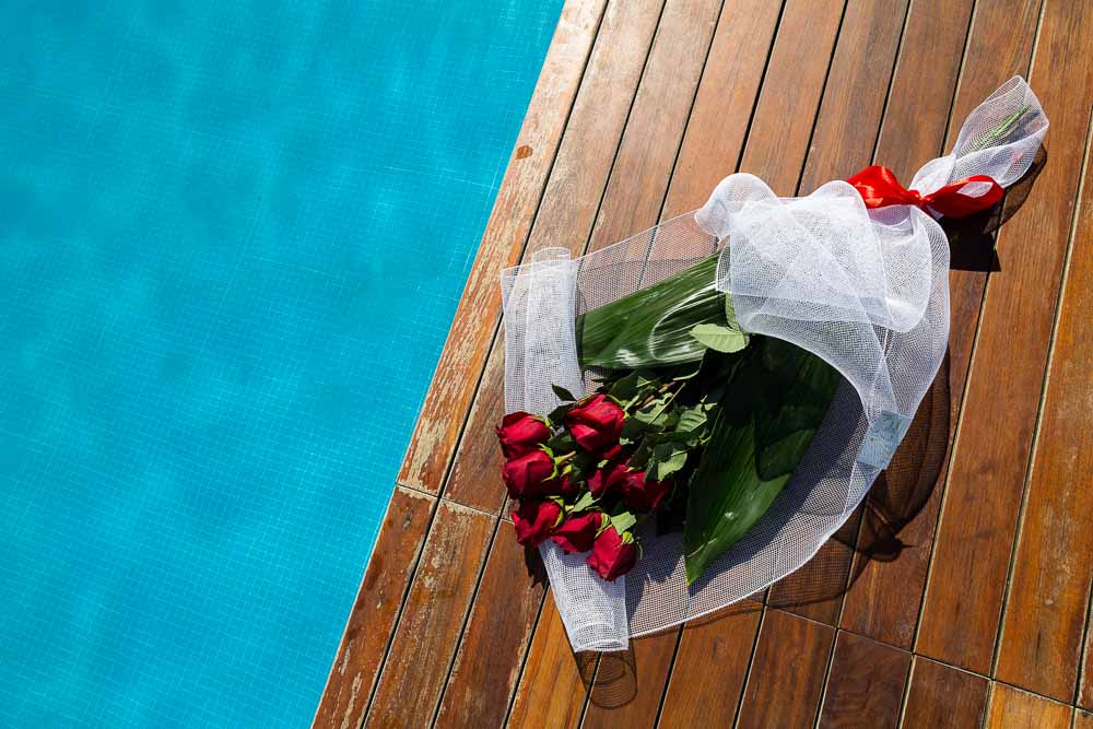 Bright red roses paying on the ground in between pools