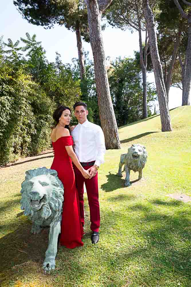 Posing by the lion statues in a grass field