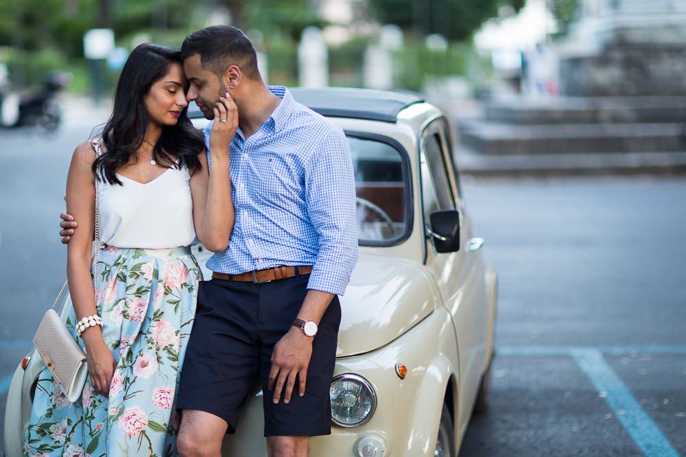 Romance in Rome. Couple photographed together leaning on a FIAT 500 vintage Italian car