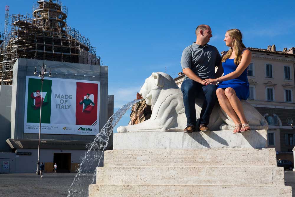 Sitting down on a lioness marble statue in Piazza del Popolo