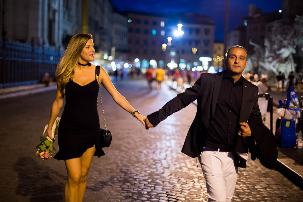 Walking hand in hand in Navona square at night