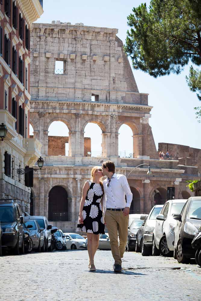 In love in Rome. Kissing in an alleyway with the Roman Colosseum in the background. Engagement photography.