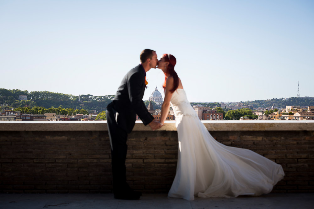 Kissing while framing Saint Peter's dome in the far distance. Rome, Italy