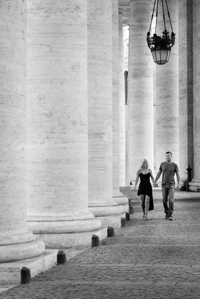 Walking under massive columns in the Vatican. Black and white image