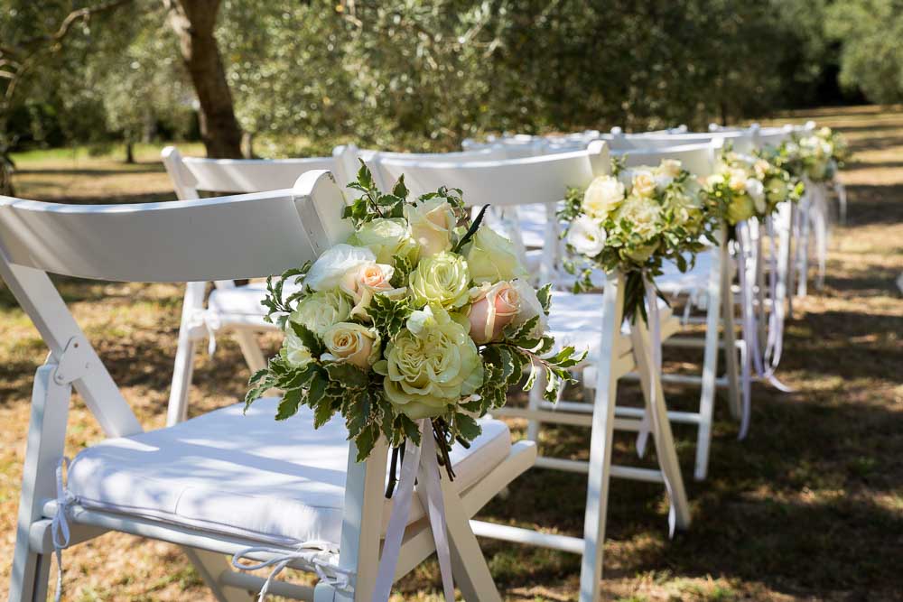 Wedding flowers preparations on the chairs