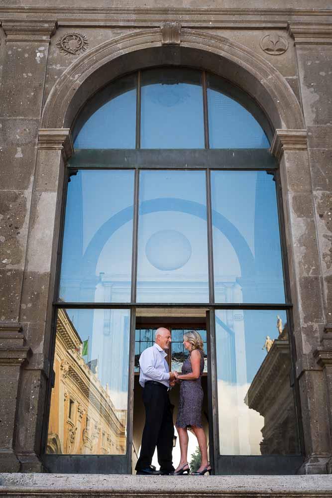 Standing on a glass doorway with the reflection of Rome in background