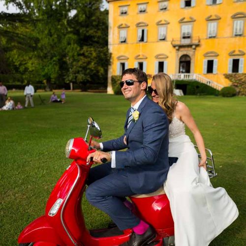 Married and taking a ride on a red Vespa in the Italian Tuscany countryside villa estate