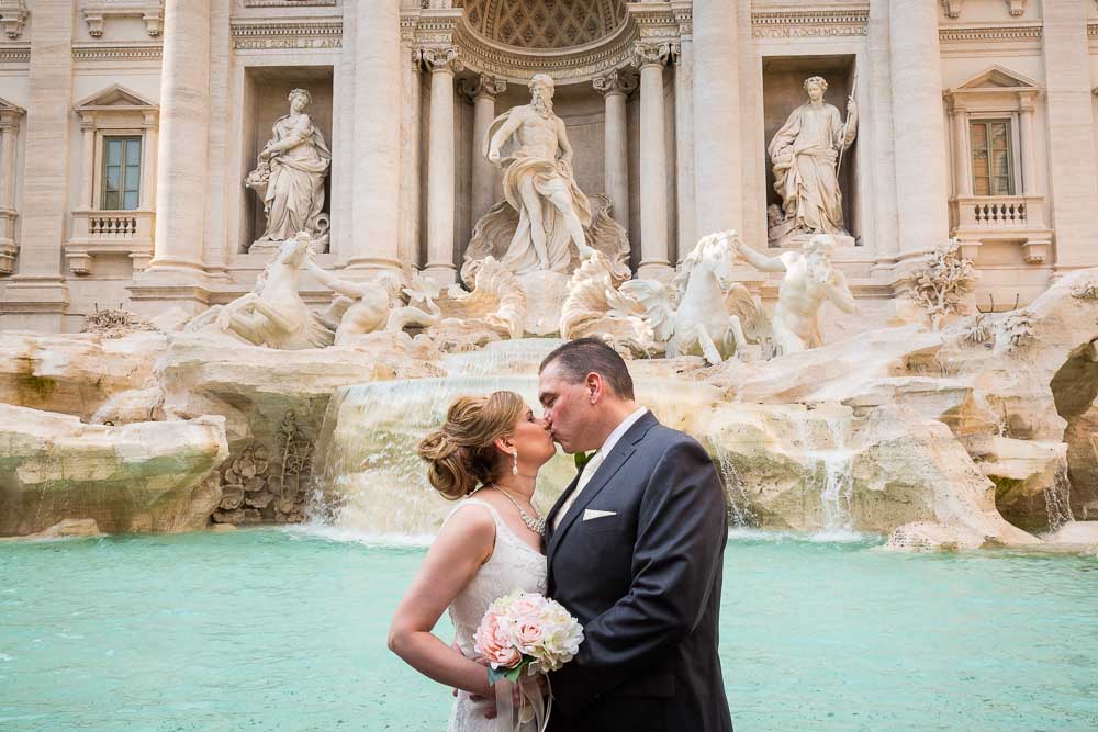 Newlyweds kissing at the Trevi fountain