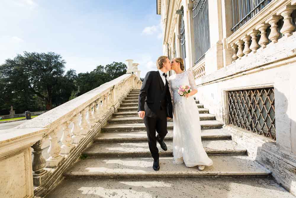 Kissing while walking wed photo shoot. Descending staircase.
