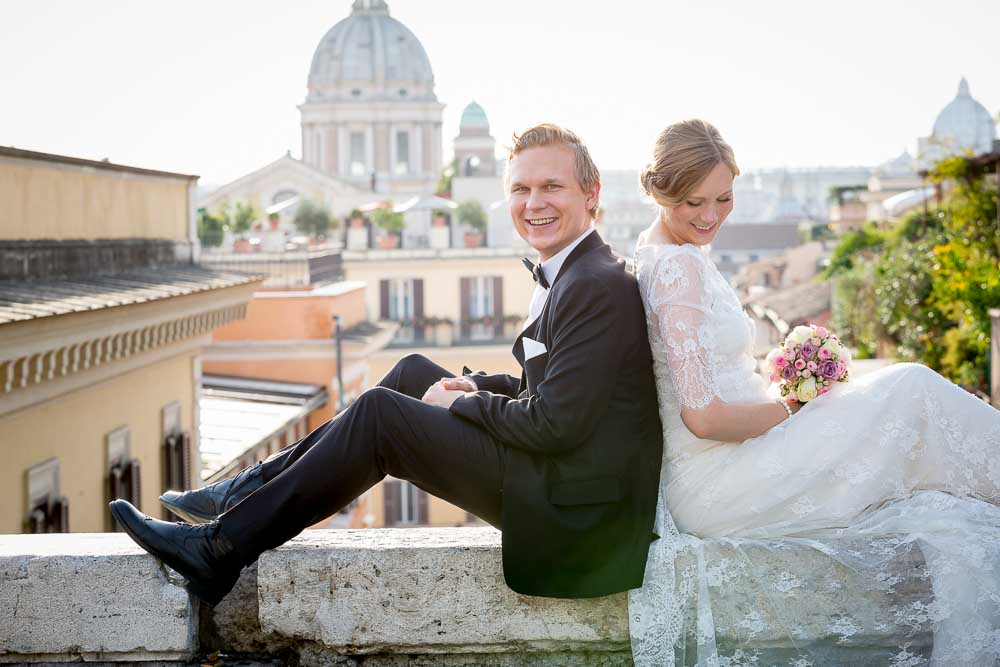 Groom and bride portrait before the Roman rooftops. In the center of Rome Italy