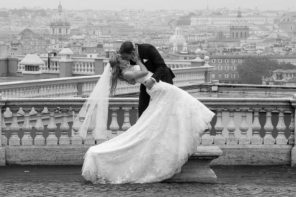 Grrom dipping the bride overlooking the roman rooftops