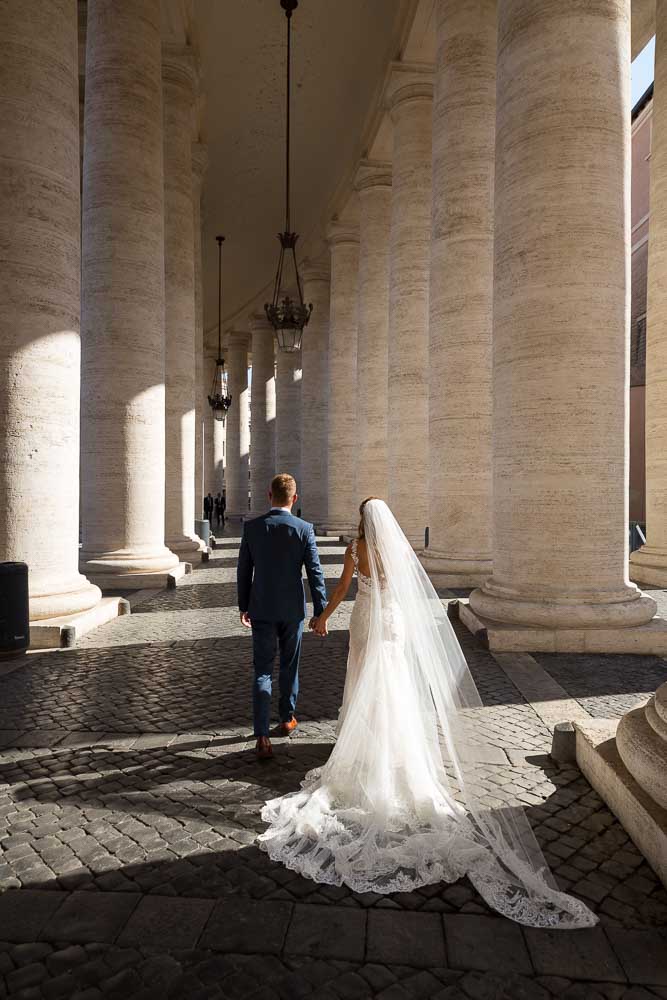 Walking underneath large marble columns at the Vatican