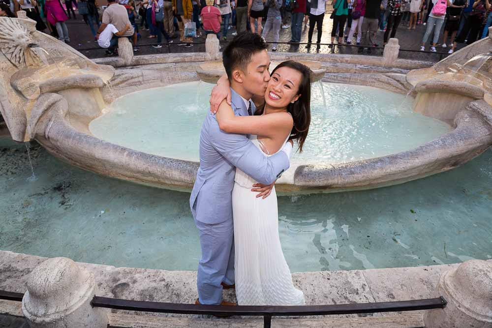 Happy picture of a couple in love by a typical Italian water fountain