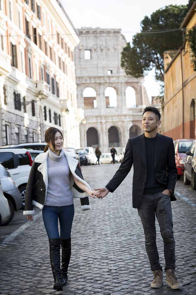 Walking hand in hand in the ancient roman alleyways among cobble stone streets